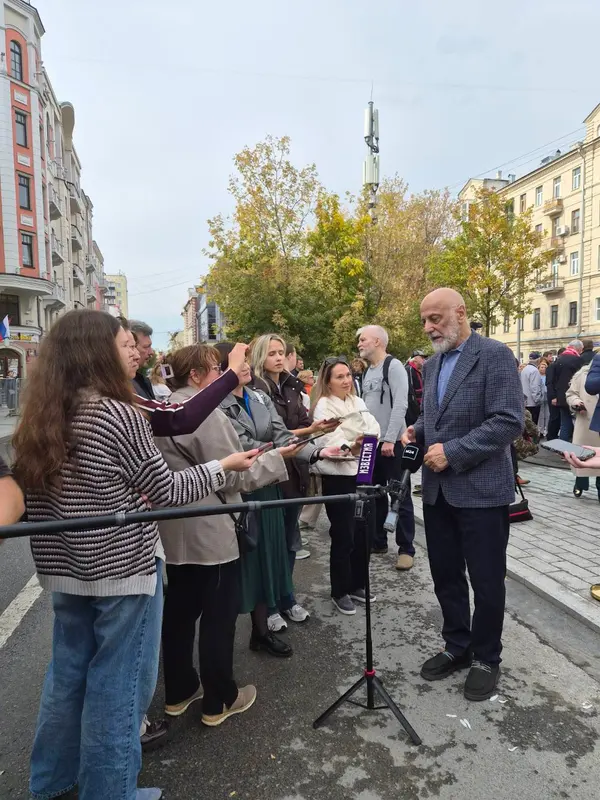 A crowd gathers around a speaker in a city street in Russia